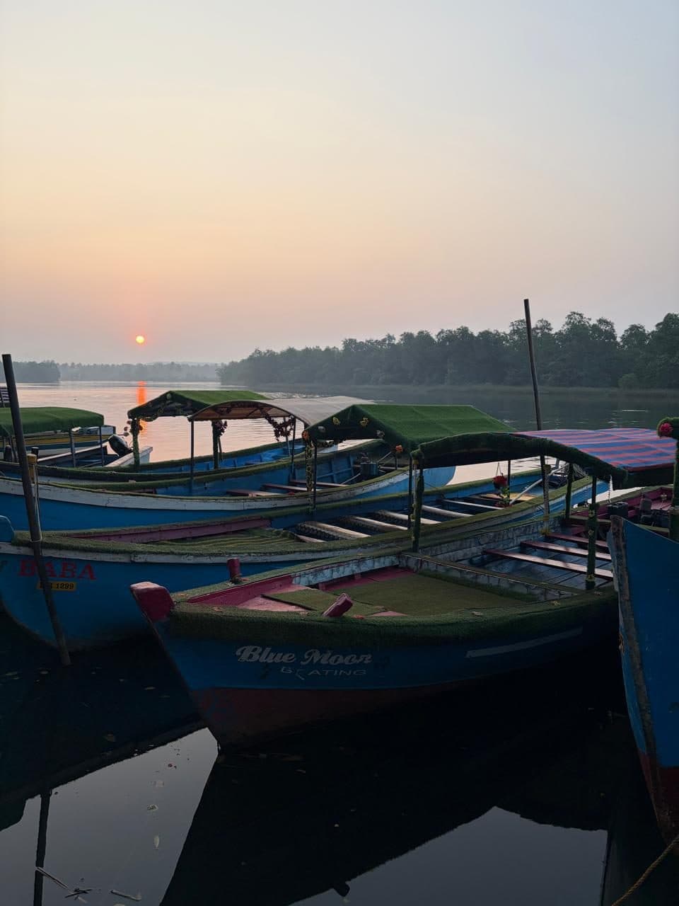 Boats at the jetty as the sun sets over the backwaters