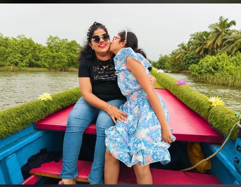 Family on the pink and blue boat in the mangroves