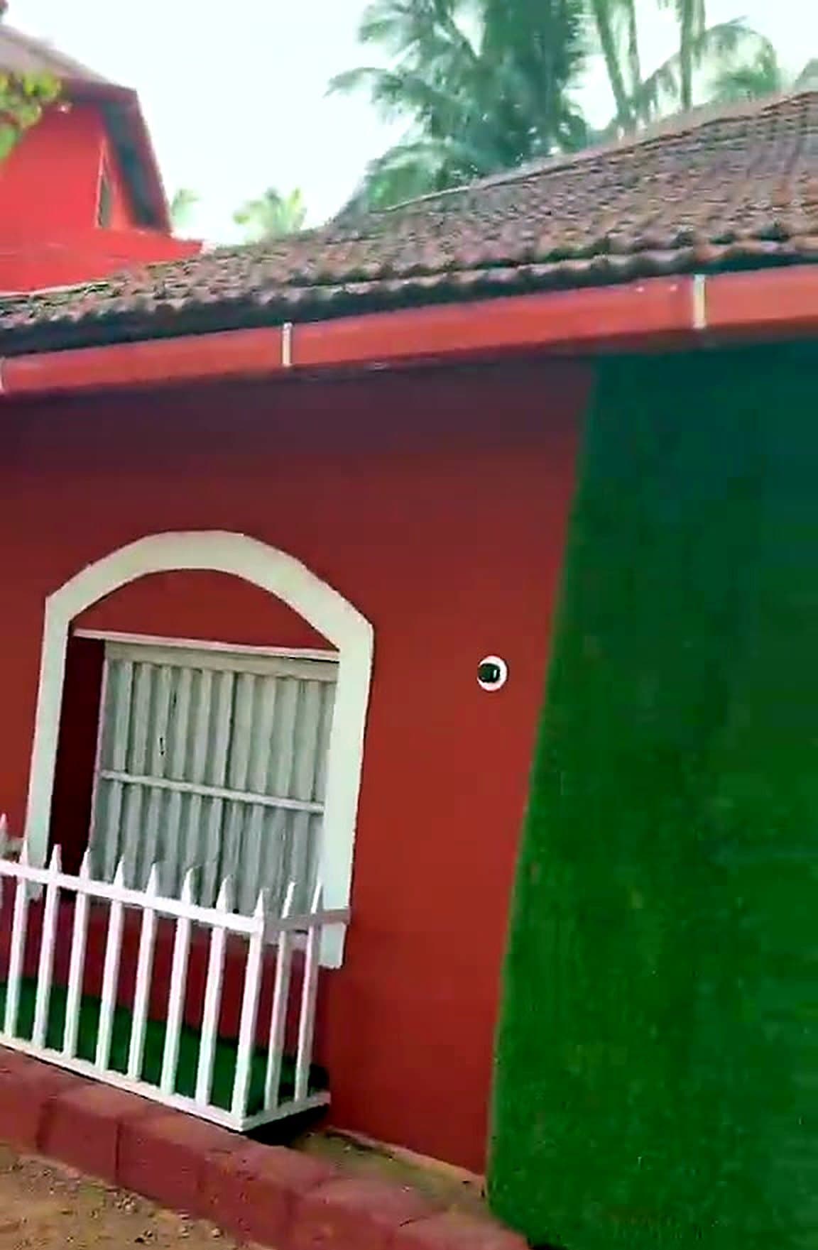 Front of the homestay with green door and arched windows