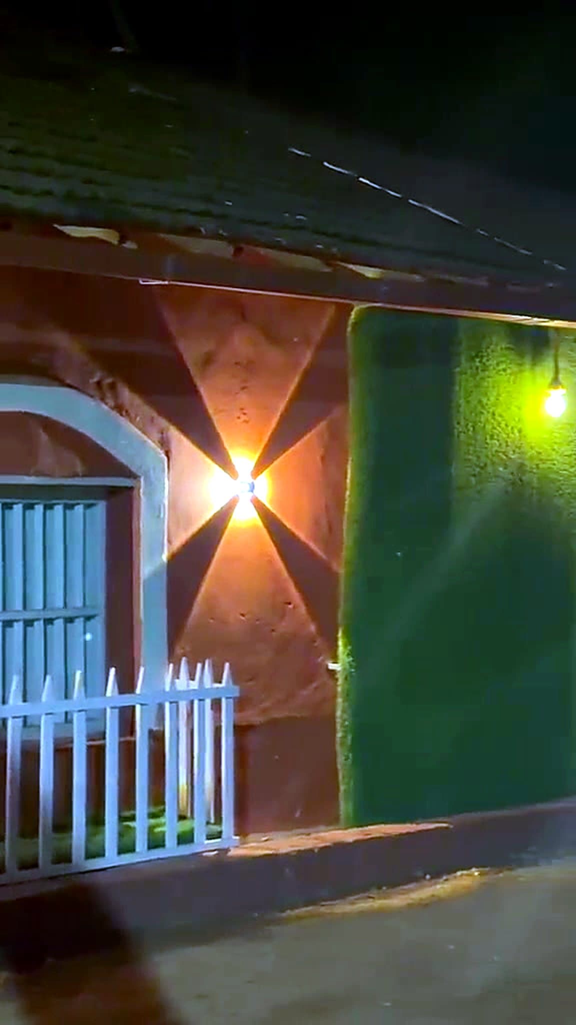 The homestay lit by wall lamps at night