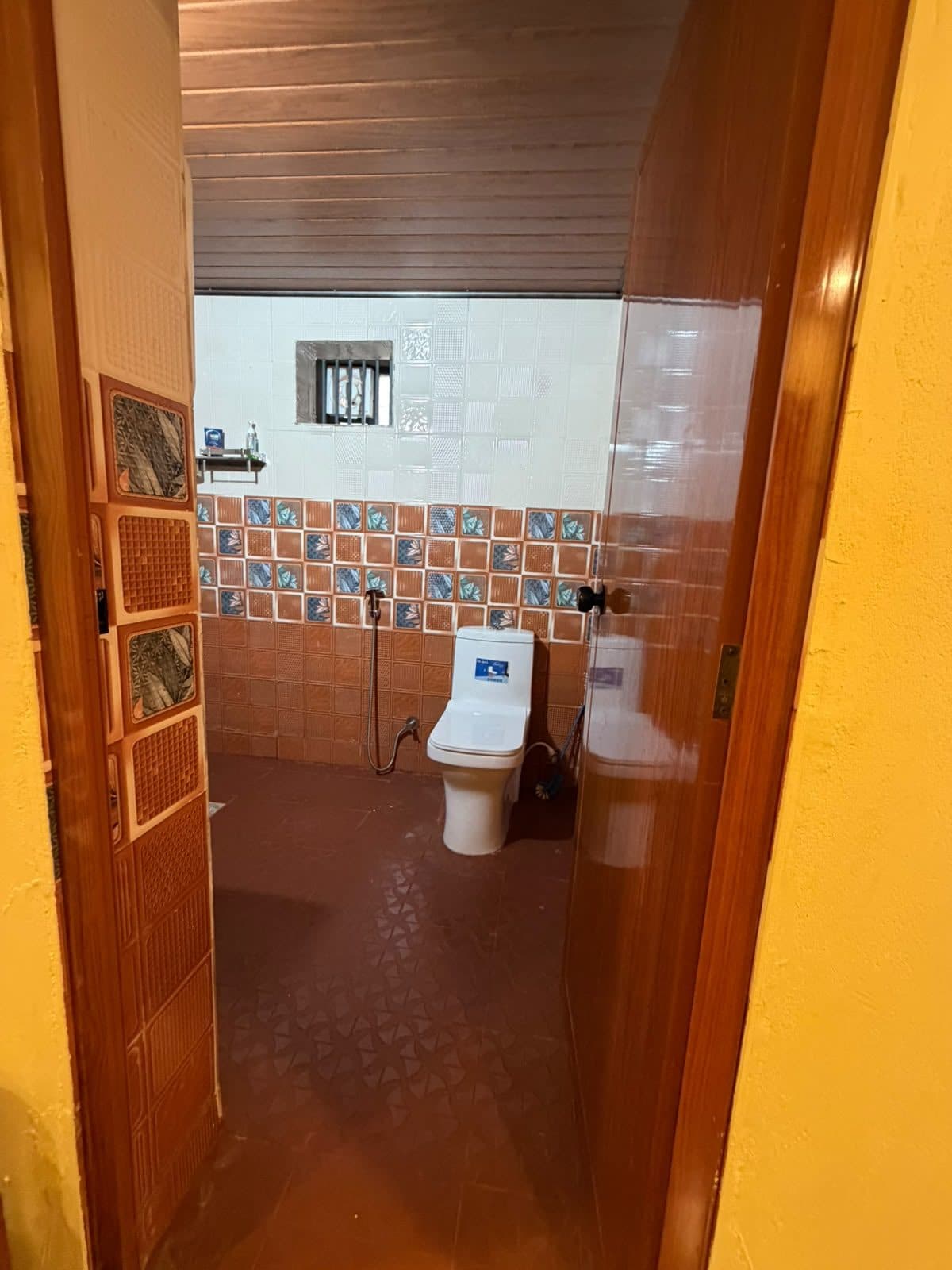 Bathroom with western toilet and tiled walls