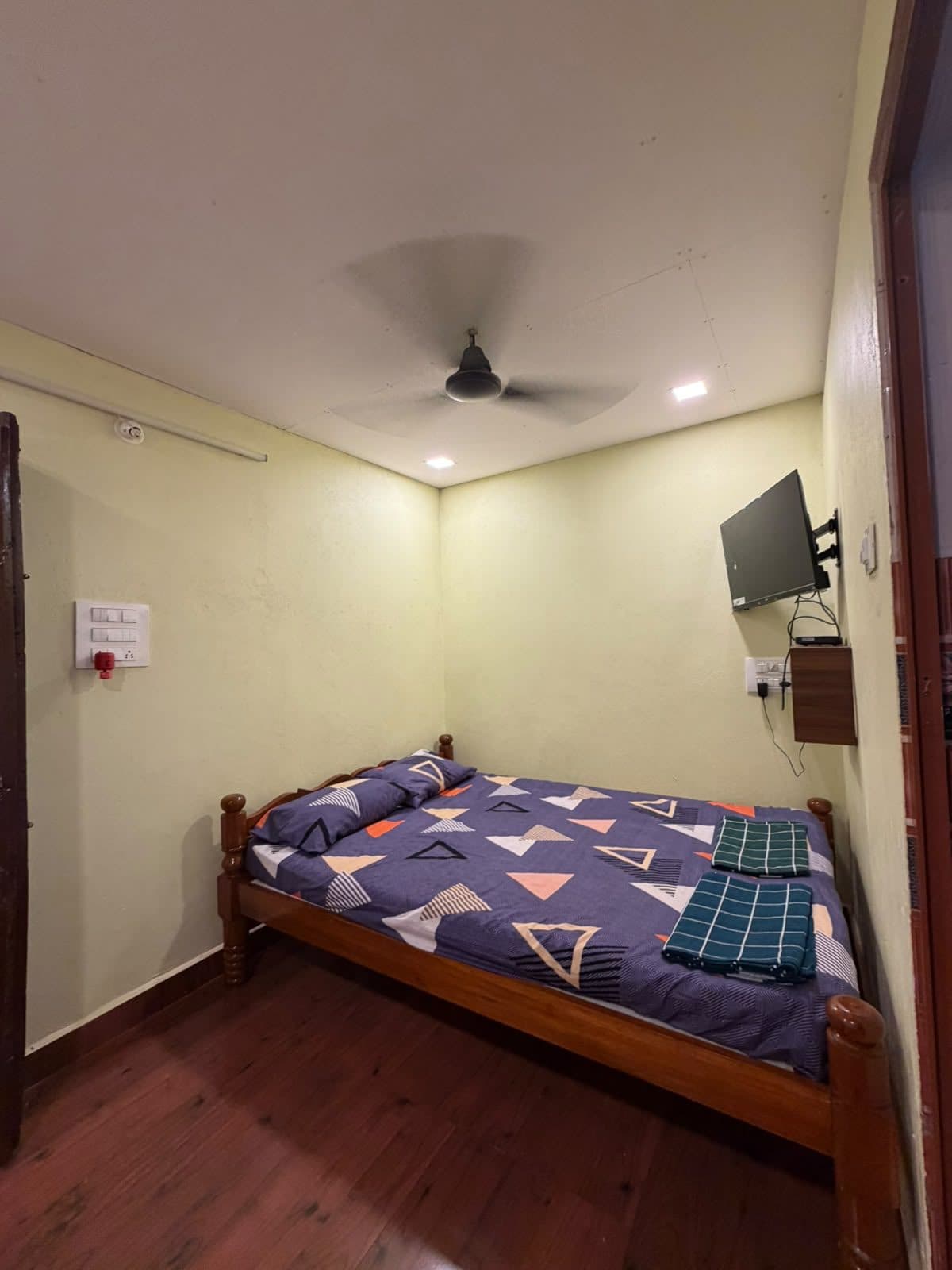 Wooden double bed with fresh linen and towels