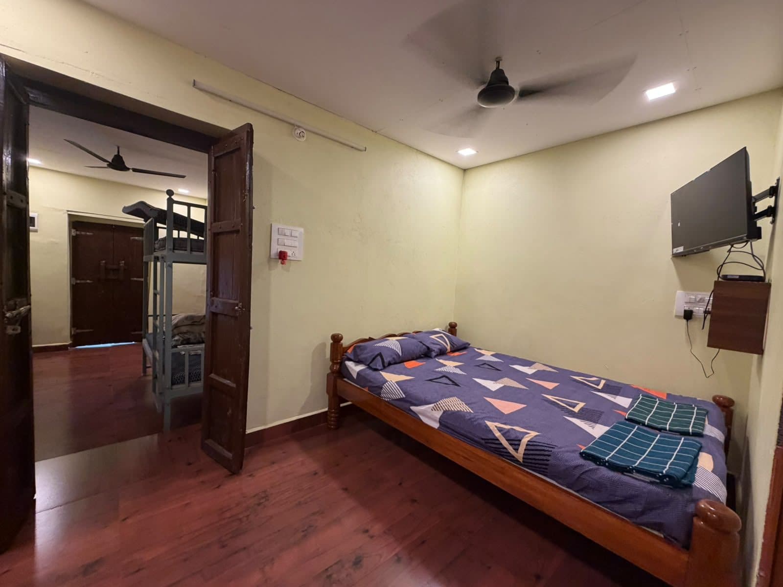 Double room with wooden bed, TV and heritage timber doors