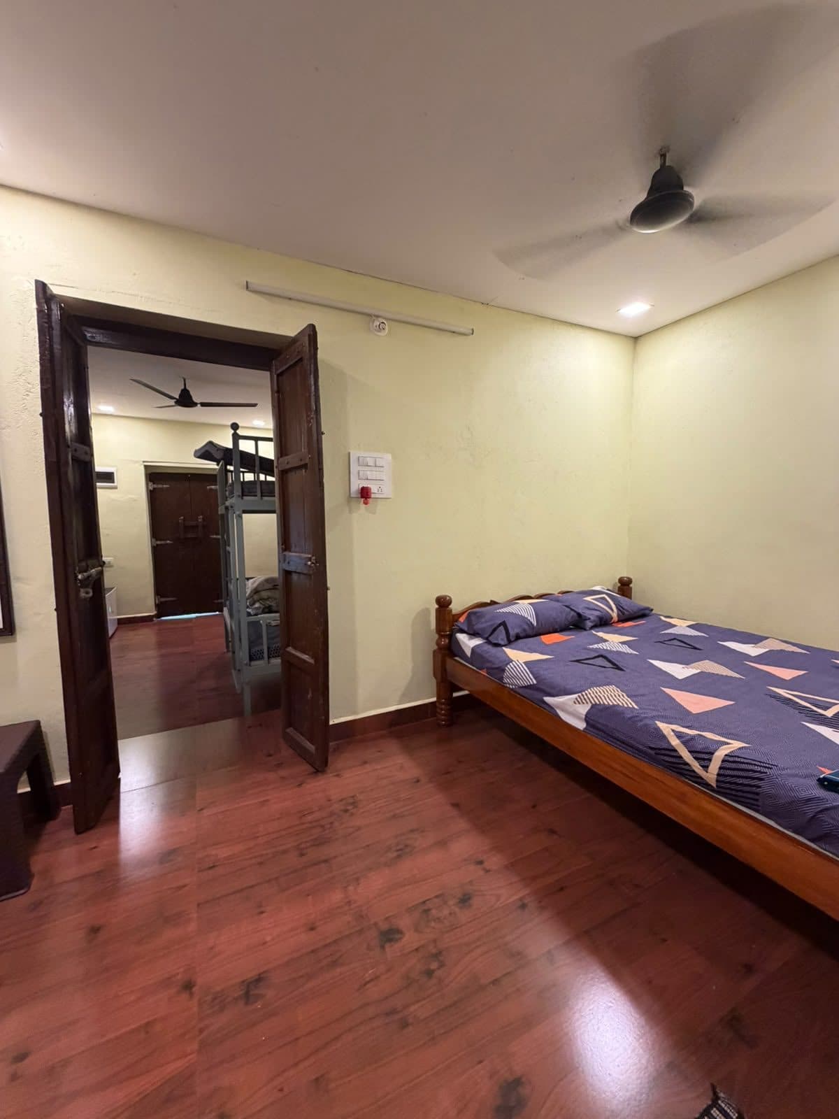 Double room looking through old wooden doors to the bunk room